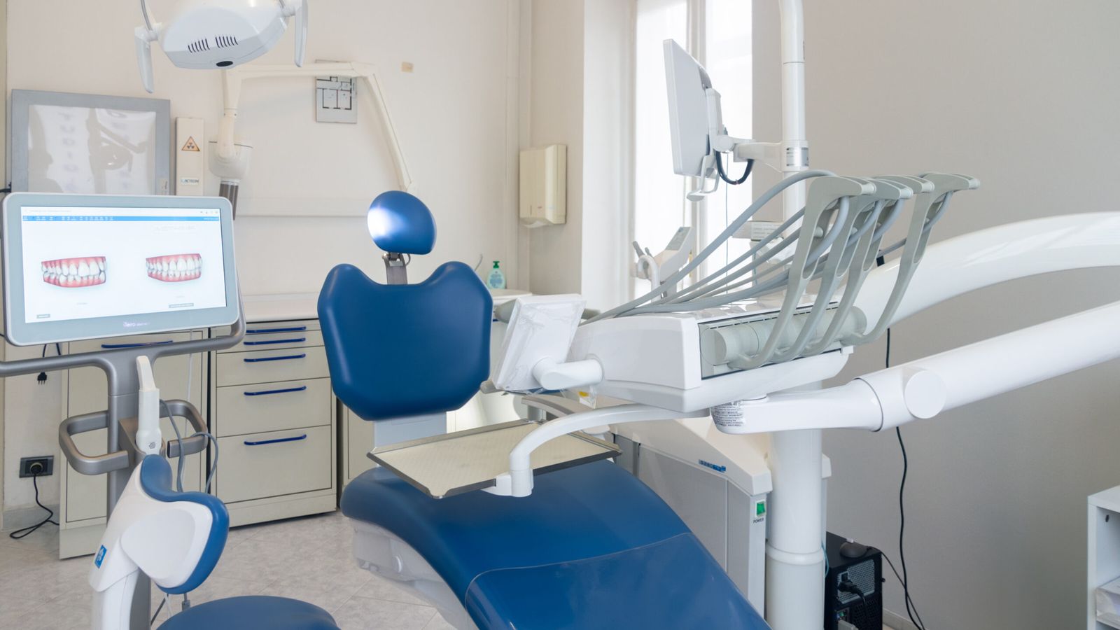 Una sala di cura dello studio, con la poltrona blu e lo schermo per la pianificazione